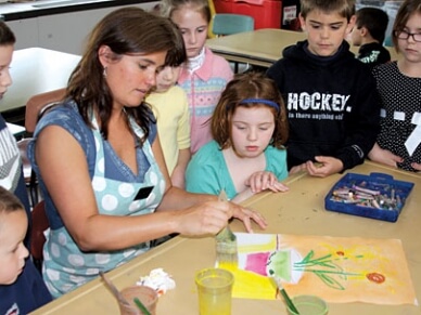 Adult teaching painting to children